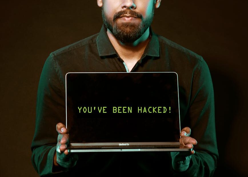 man holding laptop computer with both hands